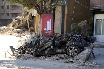 A destroyed car and rubble on a street in the Dahiyeh area of Beirut, Lebanon, following air strikes on March 9, 2026.