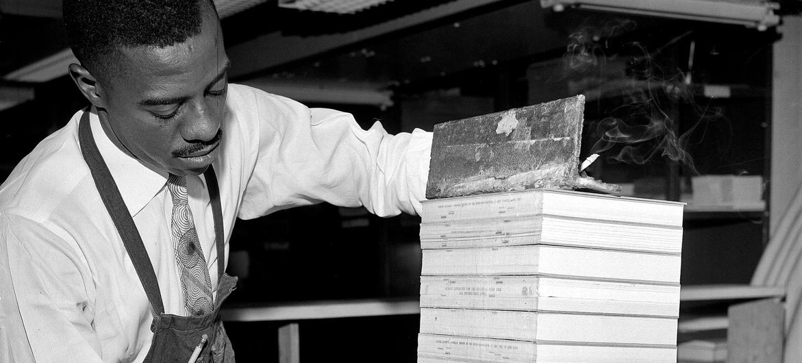 Head of bookbinding at the Reproduction Unit, William L. Watson demonstrated a step in a new technique he helped to develop in 1952. (file)