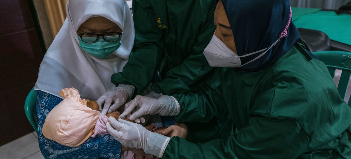 A child is vaccinated at a health centre in East Java Province, Indonesia during the COVID pandemic in 2021.