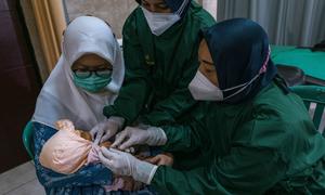 A child is vaccinated at a health centre in East Java Province, Indonesia during the COVID pandemic in 2021.