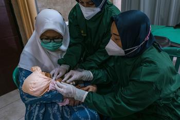 A child is vaccinated at a health centre in East Java Province, Indonesia during the COVID pandemic in 2021.