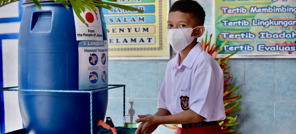 A student hygiene ambassador demonstrates how to properly wash hands  at a school in Makassar, South Sulawesi Province, Indonesia.