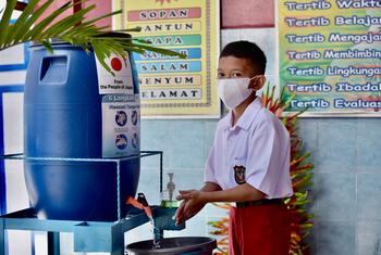 A student hygiene ambassador demonstrates how to properly wash hands  at a school in Makassar, South Sulawesi Province, Indonesia.