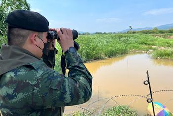A Thai army officer looks across the border into Myanmar