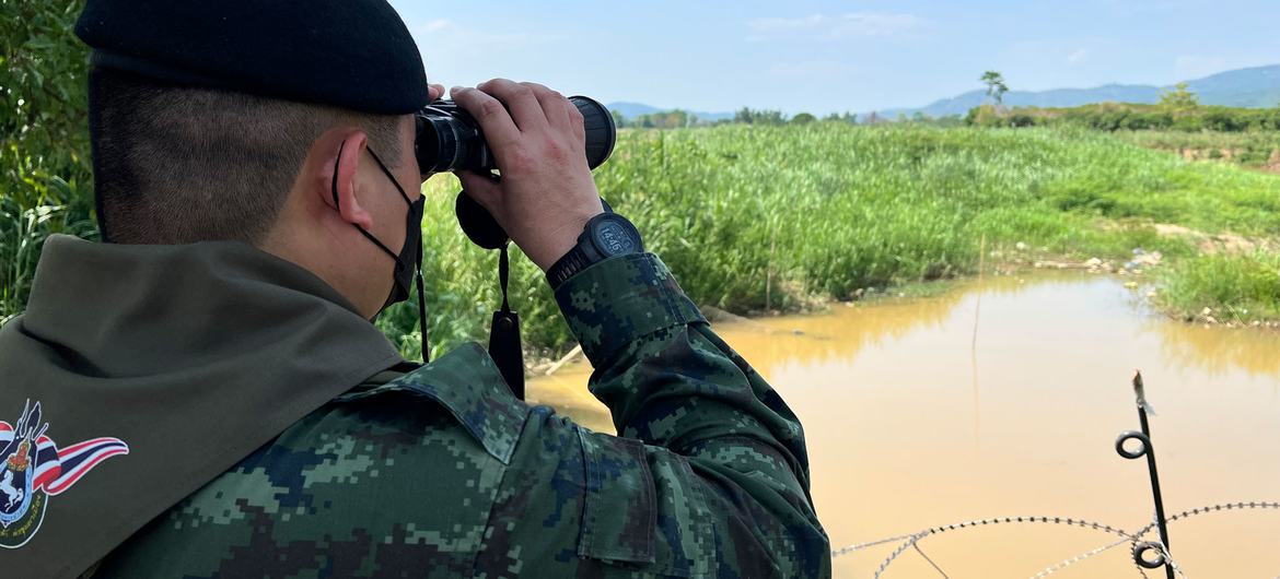 A Thai border officer looks into Myanmar across the frontier between the two countries.