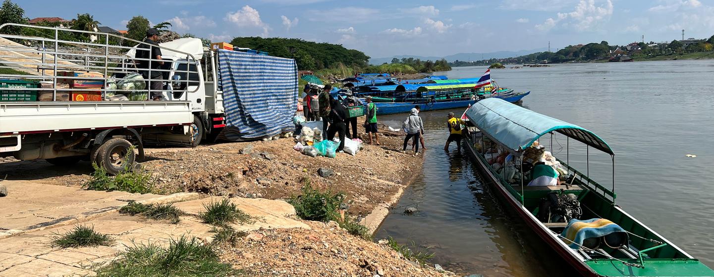 Mallar, Mekong nehri üzerinden Tayland'a taşınmak üzere Laos'ta bir tekneye yüklenir.