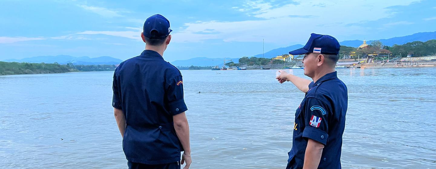 Village security volunteer, Eakkachai Suphan, (left) and a colleague look over the Mekong River in the Golden Triangle. 