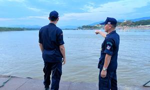 Village security volunteer, Eakkachai Suphan, (left) and a colleague look over the Mekong River in the Golden Triangle. 