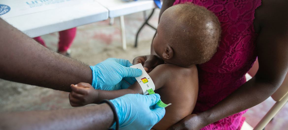 A toddler's arm is measured to determine malnutrition at a clinic run by UNICEF, in Cité Soleil, Haiti.