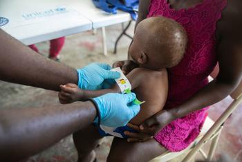 在海地索莱尔市联合国儿童基金会运营的一家诊所里，医护人员正在测量幼儿的手臂以确定其是否营养不良。