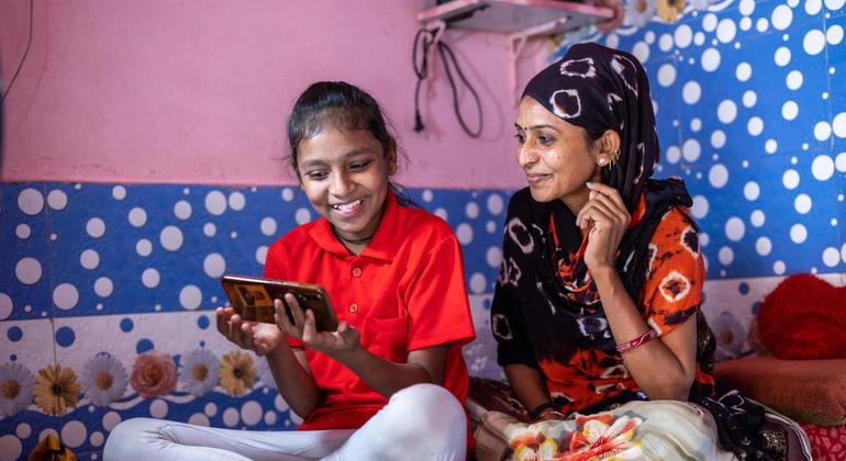 Мать помогает дочери заниматься в Интернете во время закрытия школ в период COVID-19 в Индии. 