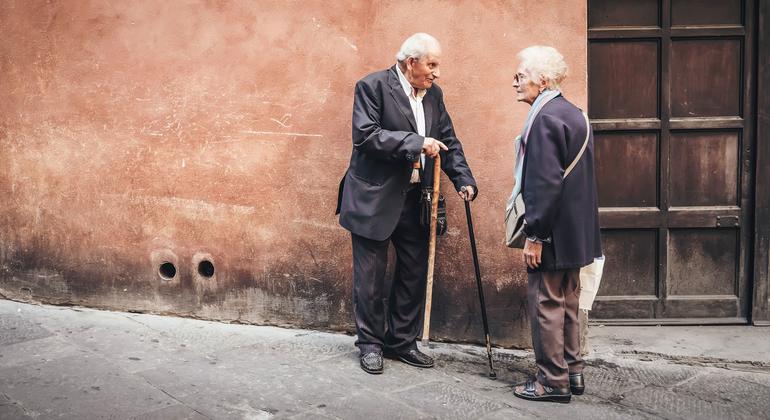 زوجان من كبار السن يقفان في أحد الشوارع في إيطاليا.