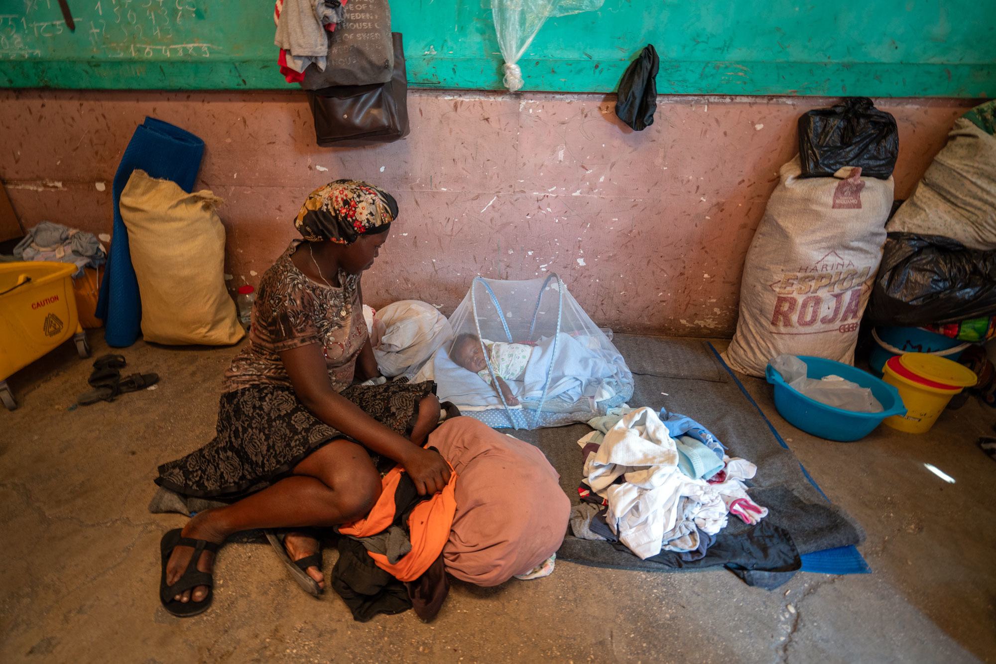 Een ontheemde moeder gaat naar een kleuterschool in de stad Port-o-prinses, Haïti voor haar kind.