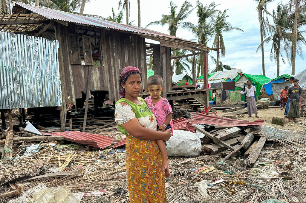 Ma Phyu Ma, una mujer rohingya, permanece de pie junto a su hijo en medio de los escombros provocados por el ciclón Mocha en una aldea del estado de Rakhine, Myanmar.