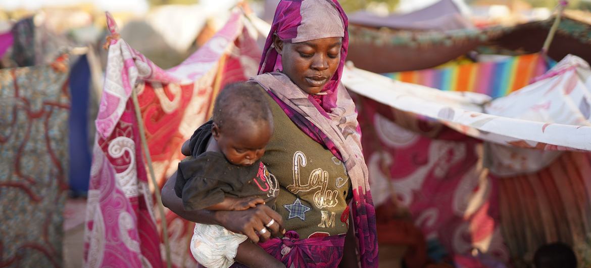 A woman walks through a camp for people who fled violence in North Darfur. A woman walks through a camp for people who fled violence in North Darfur.