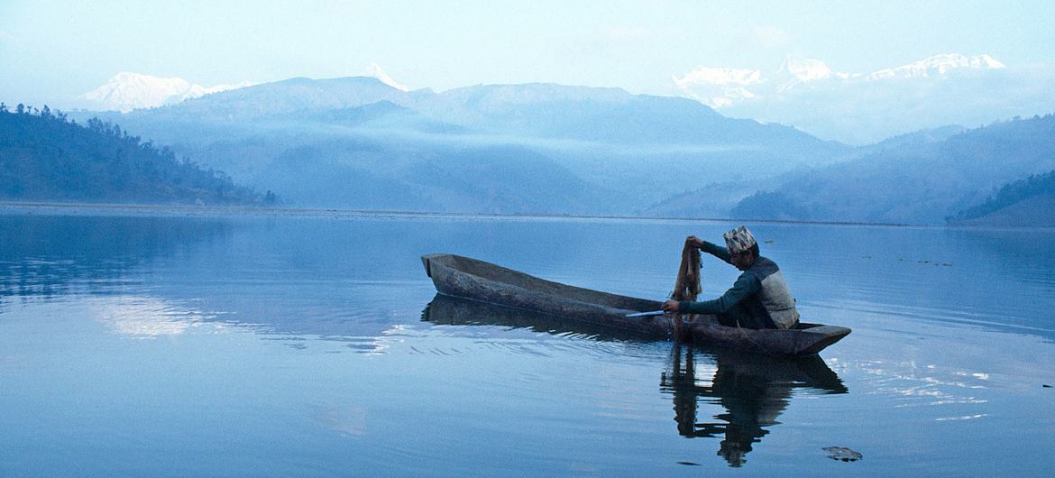 A man fishes on Lake Fewa in Nepal.