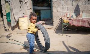 A young Yemeni child plays with a tyre on the road to recovery after suffering from malnutrition.