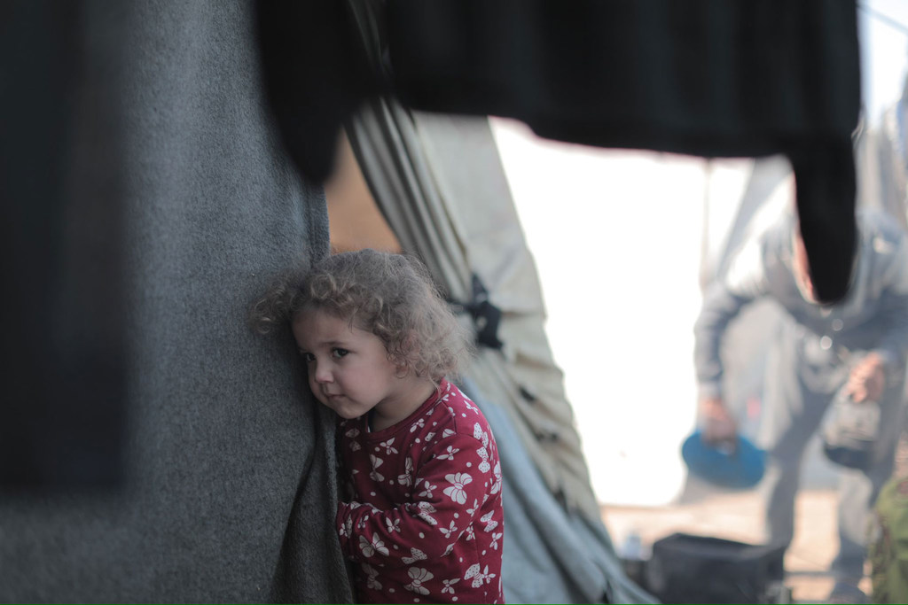 Une fillette regarde depuis une tente à Gaza.