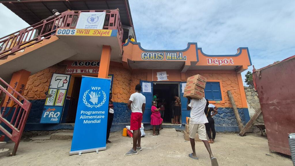 Les familles du sud-est d'Haïti reçoivent de l'aide alimentaire par le biais d'un système de coupons dans un magasin local.