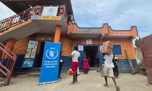 A family receives food assistance from the World Food Programme (WFP) in Haiti through a voucher system at a local store called 'God's Will Dépôt'.
