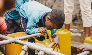 A child fills a container at a water tap installed by UNICEF in Kanyaruchinya near Goma, in the eastern DR Congo.