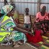 Sudan Kusini. Mwanamke akimpima mtoto kwa ajili ya uchunguzi wa utapiamlo kwenye eneo la usambazaji wa misaada ya WFP.