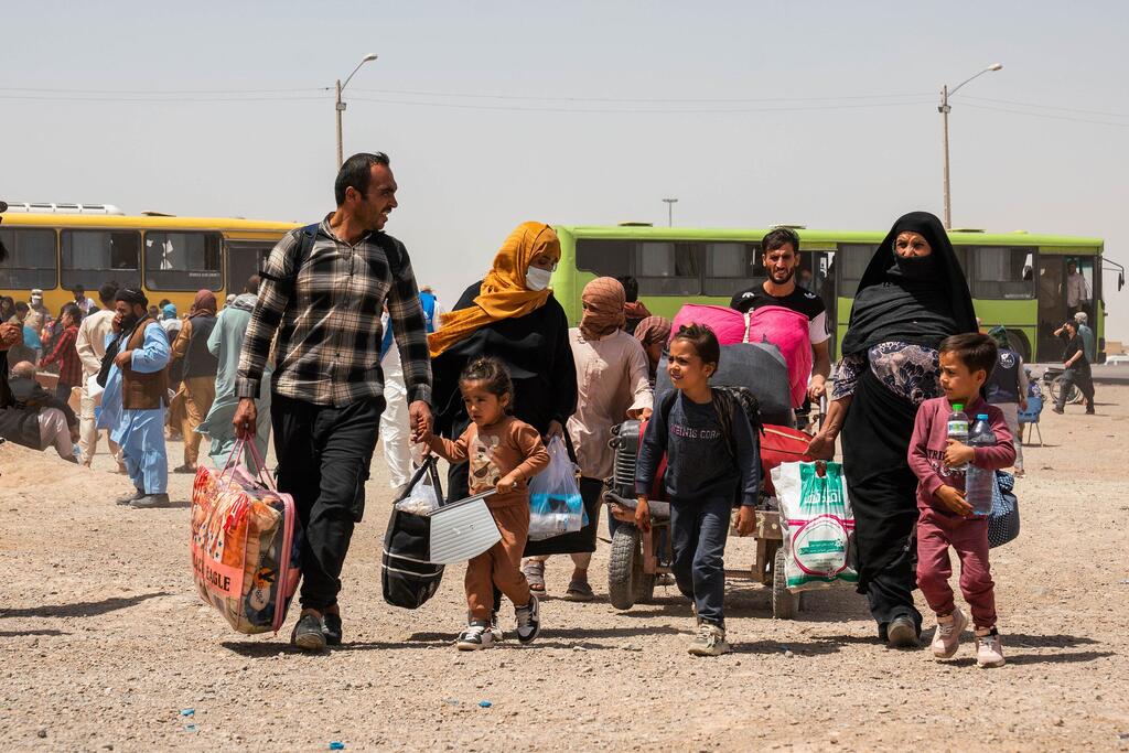 Афганские семьи пересекают границу из Ирана в Афганистан.