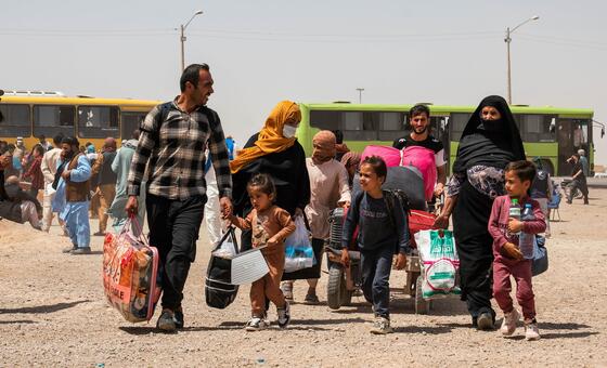 Афганские семьи пересекают границу из Ирана в Афганистан.