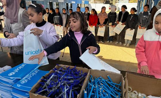 أطفال فلسطينيون في دير البلح، وسط قطاع غزة يستلمون مستلزمات مدرسية من منظمة اليونيسف.