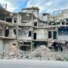 A child runs past piles of rubble in front of heavily damaged buildings in Homs, Syria, during a UNICEF field visit on October 7, 2025.