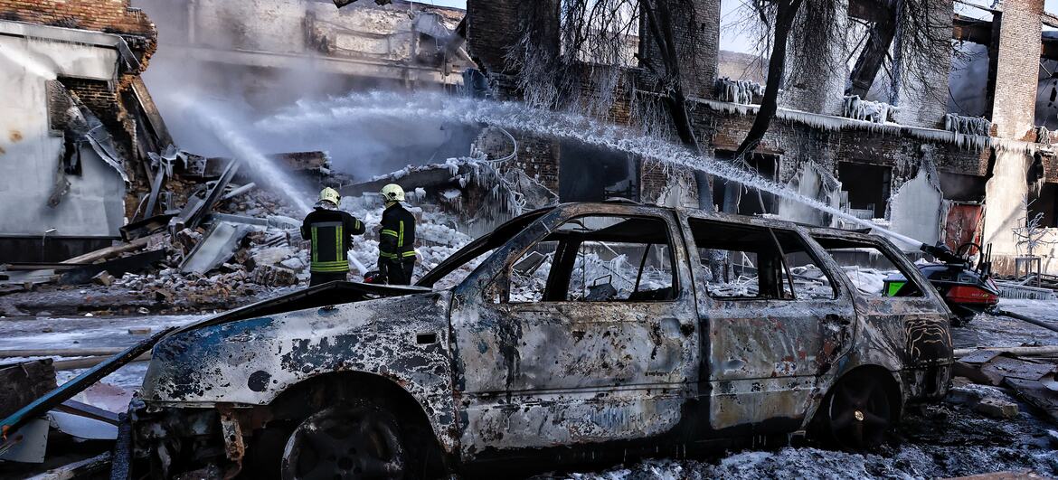Пожарные в Киеве, Украина, борются с пожаром в сильно поврежденном промышленном здании в условиях холодной зимы. Лед покрывает конструкцию и окрестности, в то время как бригады работают над контролем над огнем и предотвращением дальнейшего распространения.