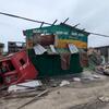 Les conséquences du cyclone Gezani à Toamasina, Madagascar, montrant des bâtiments détruits, des débris et un camion renversé, soulignant l'impact grave de la catastrophe naturelle.