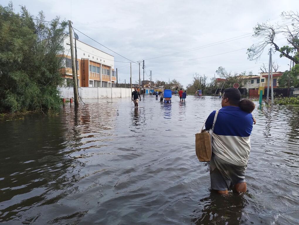 Des habitants de Toamasina, deuxième ville de Madagascar, dans le nord-est, traversent des rues inondées après que le passage, le 10 février, du cyclone Gezani.
