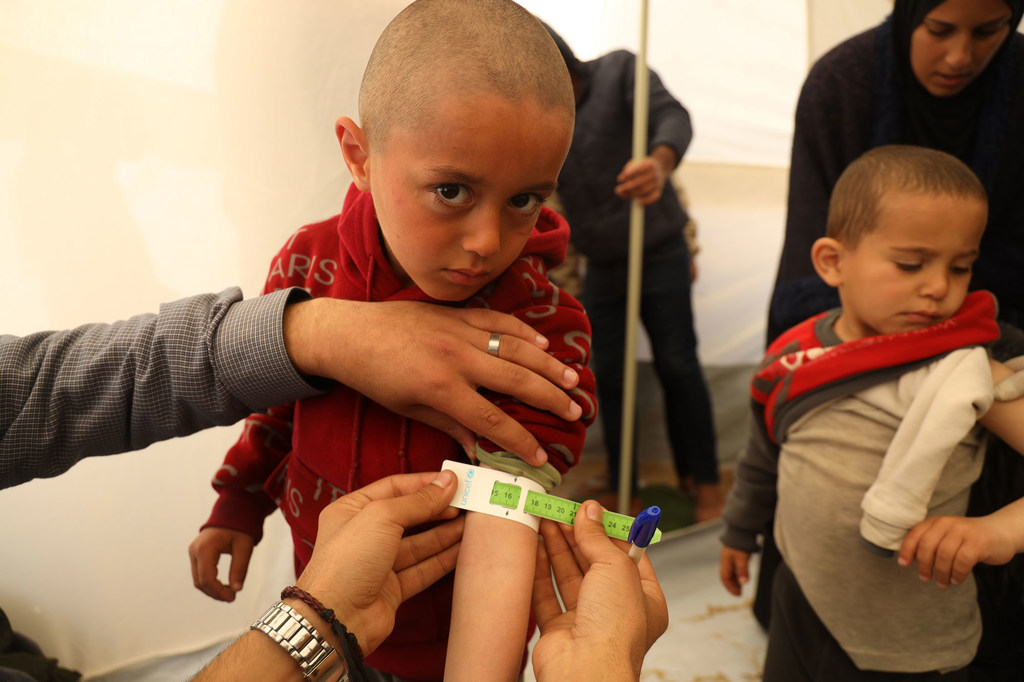 Mohammad is getting measured as part of a malnutrition screening at a UNICEF-supported pediatrician clinic tent in Rafah city, south of the Gaza Strip.