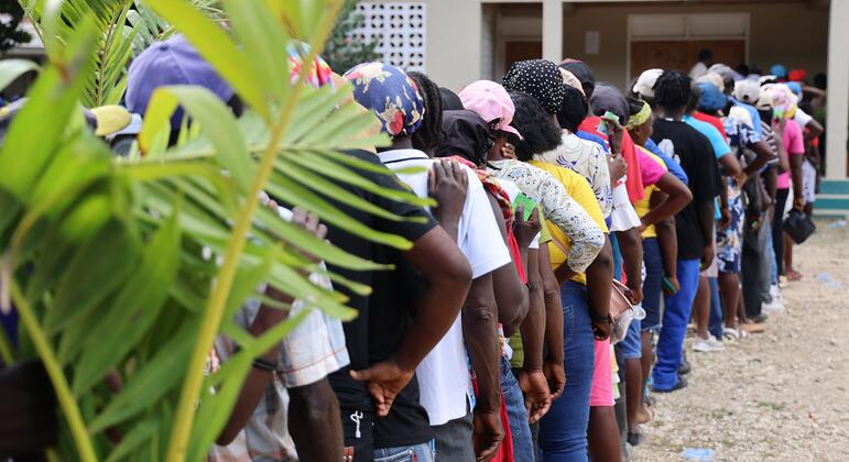 参与者站在海地分销场所排队.