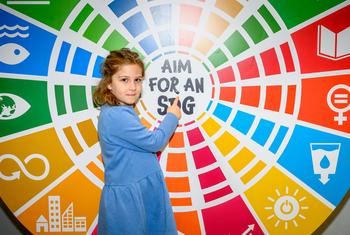 Une fillette montre son soutien aux ODD au siège de l'ONU.