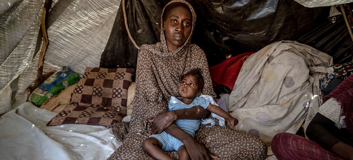 Halima, 30, holds her six-month-old daughter Samira, who has Down syndrome and was recently treated for malnutrition, inside a tent in a displacement camp in Tawila, North Darfur, Sudan.