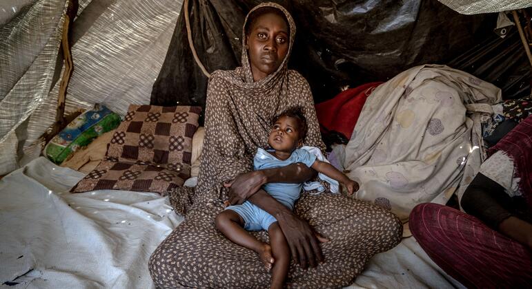 حليمة، البالغة من العمر 30 عاماً، التي هربت من القتال في مدينة الفاشر القريبة، تحمل ابنتها سميرة، البالغة من العمر ستة أشهر، والتي تعاني من متلازمة داون وعولجت مؤخراً في تاويلا بسبب سوء التغذية.