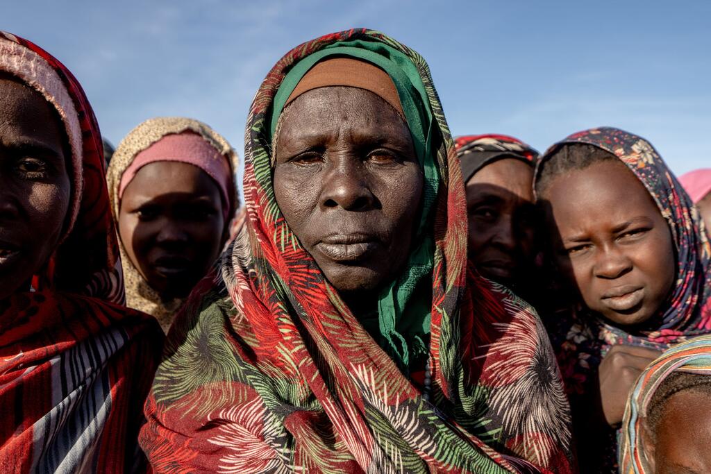 نساء وفتيات سودانيات نازحات يصطففن للحصول على الطعام في مطبخ مجتمعي في طويلة بدارفور.