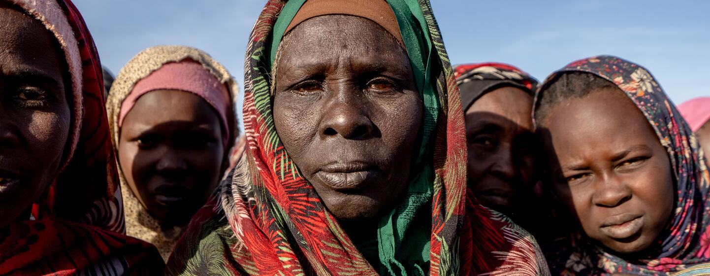 Portrait de femmes et d'enfants soudanais dans un site de distribution de repas communautaires de Save the Children, dans le camp de Daba Naira à Tawila, au Darfour du Nord, au Soudan.