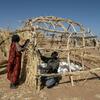 نازحون سودانيون يبنون مأوى من القش في مخيم بمدينة تاويلا، شمال دارفور، السودان.