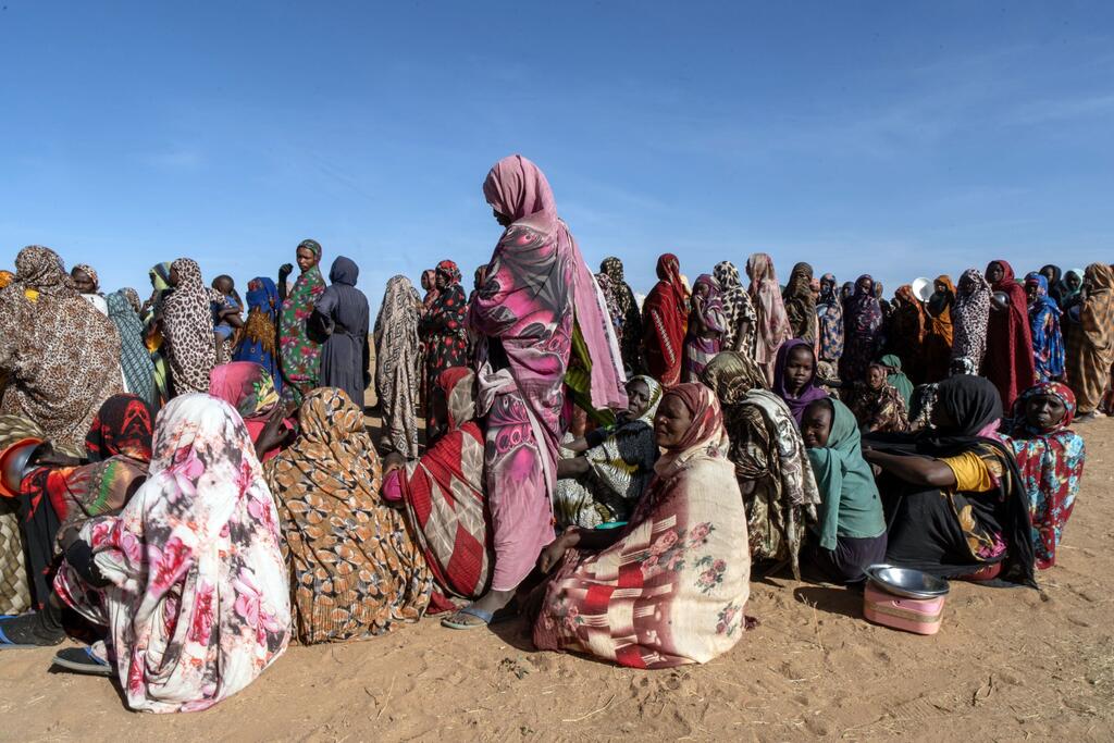 نساء فررن من منازلهن بسبب النزاع في دارفور يصطففن للحصول على الطعام في مطبخ مجتمعي في مدينة طويلة، دارفور.