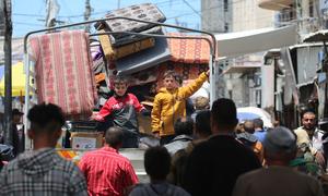 Deux enfants se tiennent à l'arrière d'un camion alors que leur famille fuit Rafah, au sud de la bande de Gaza.
