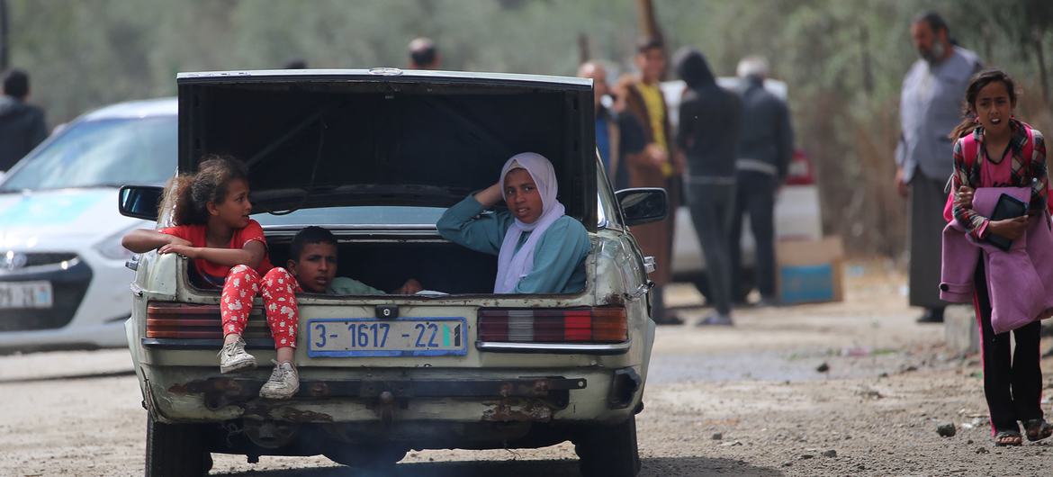 Crianças viajam no porta-malas de um carro ao deixar Rafah, no sul de Gaza
