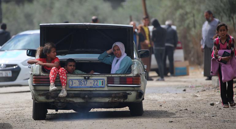 Crianças viajam no porta-malas de um carro ao saírem de Rafah, no sul de Gaza