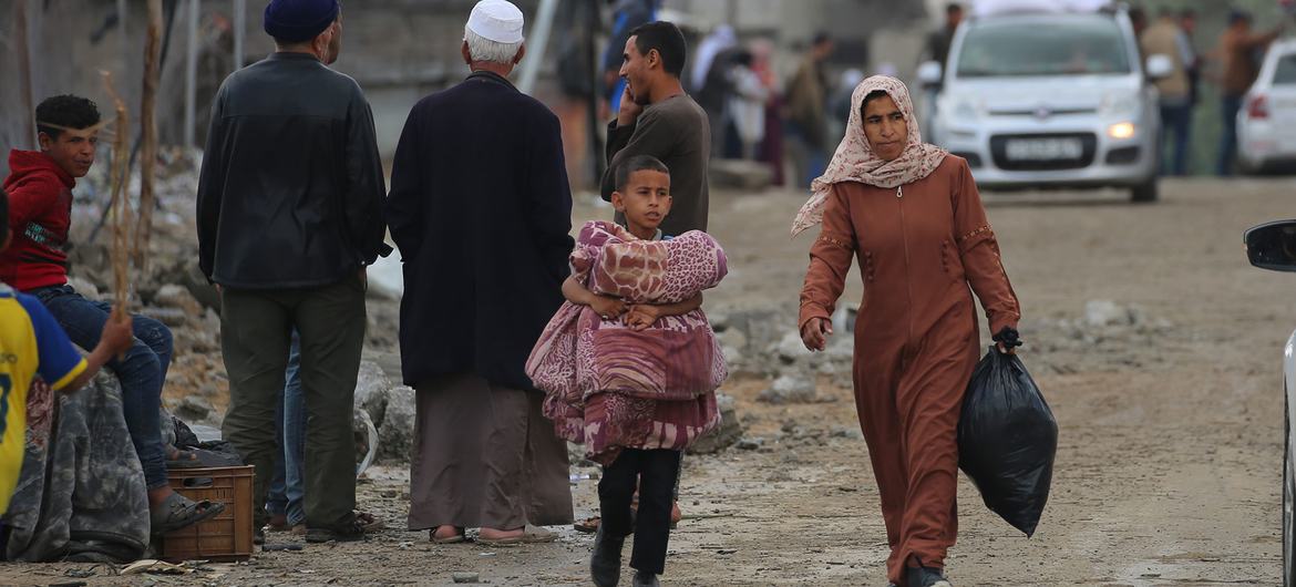 Una mujer y un niño transportan pertenencias por las calles de Rafah.