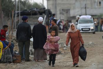 A woman and child carry possessions through the streets of Rafah.