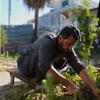 A man with a prosthetic leg tends to a vegetable garden beside a temporary shelter in Gaza.