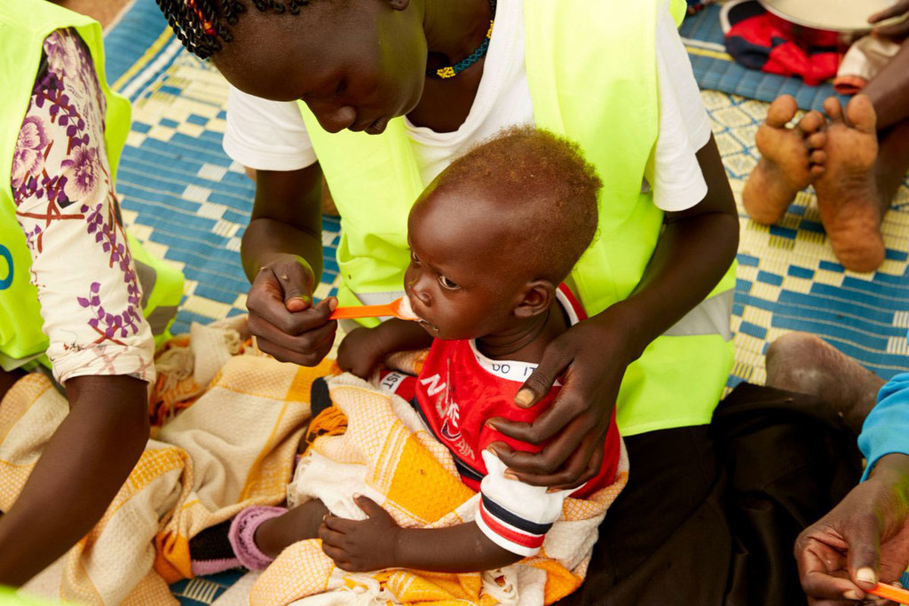 A child in South Sudan is fed by a healthcare worker.