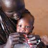 Une mère réfugiée tient son bébé dans ses bras tout en le nourrissant avec un sachet de complément nutritionnel à la frontière de Joda, au Soudan du Sud.